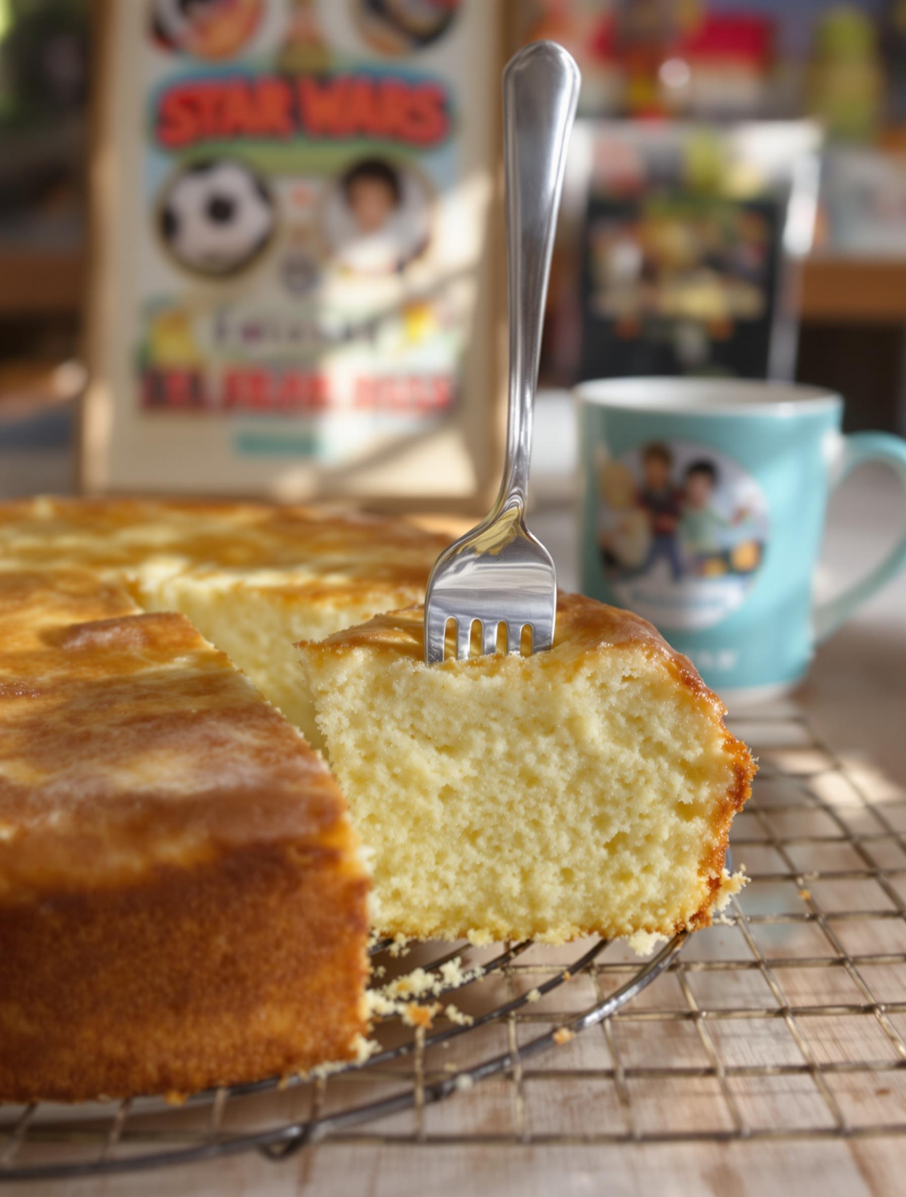Gâteau au yaourt moelleux avec croûte dorée, fourchette plantée, ambiance goûter vintage.