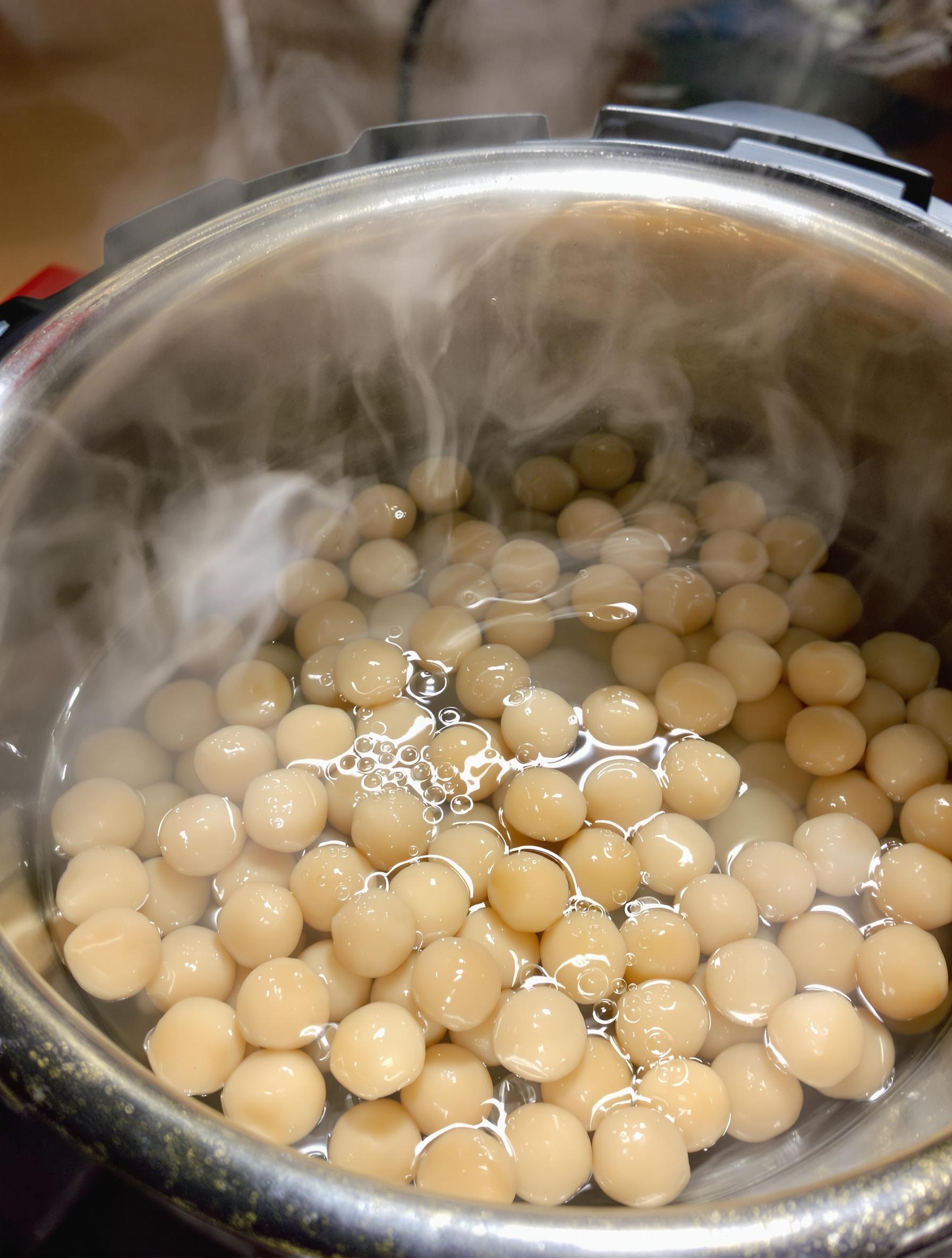 Gros plan sur la cocotte-minute remplie de pois chiches et d’eau, bulle de vapeur en action